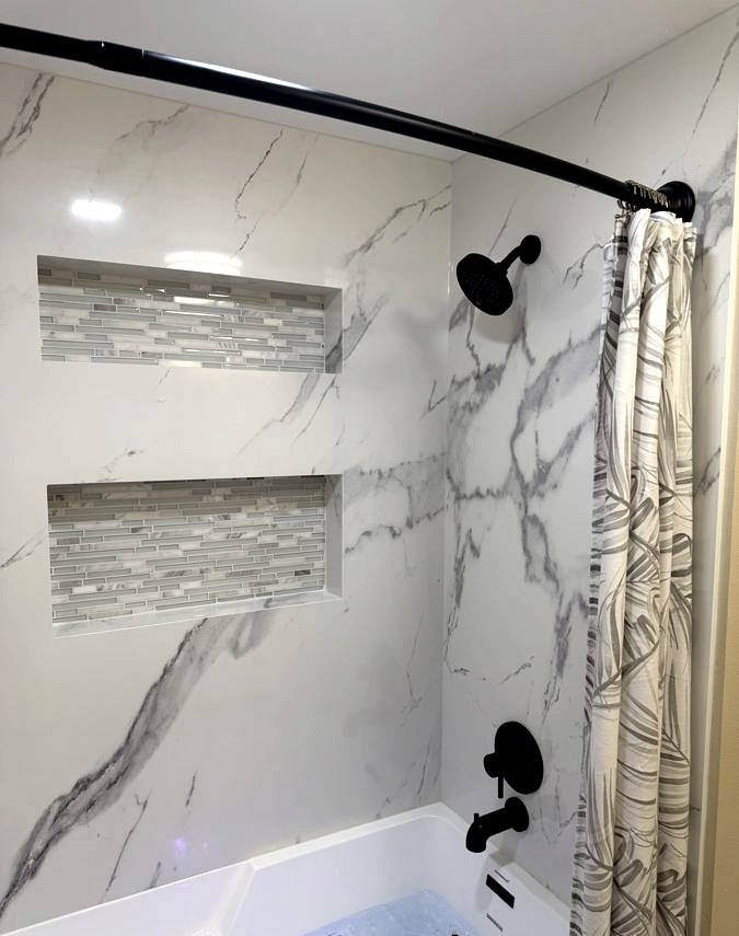 Tub & marble surround, Marble slab deck · mosaic niches by DA Interior Solutions
