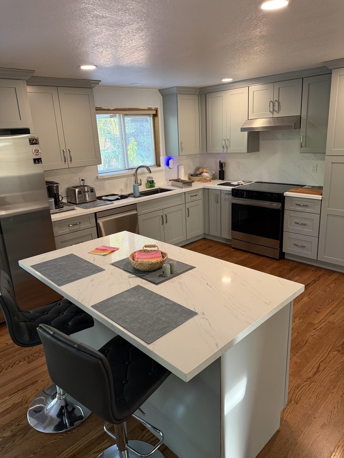 The island seats four, where the divider wall used to stand. Kitchen remodel in Lacey by DA Interior Solutions