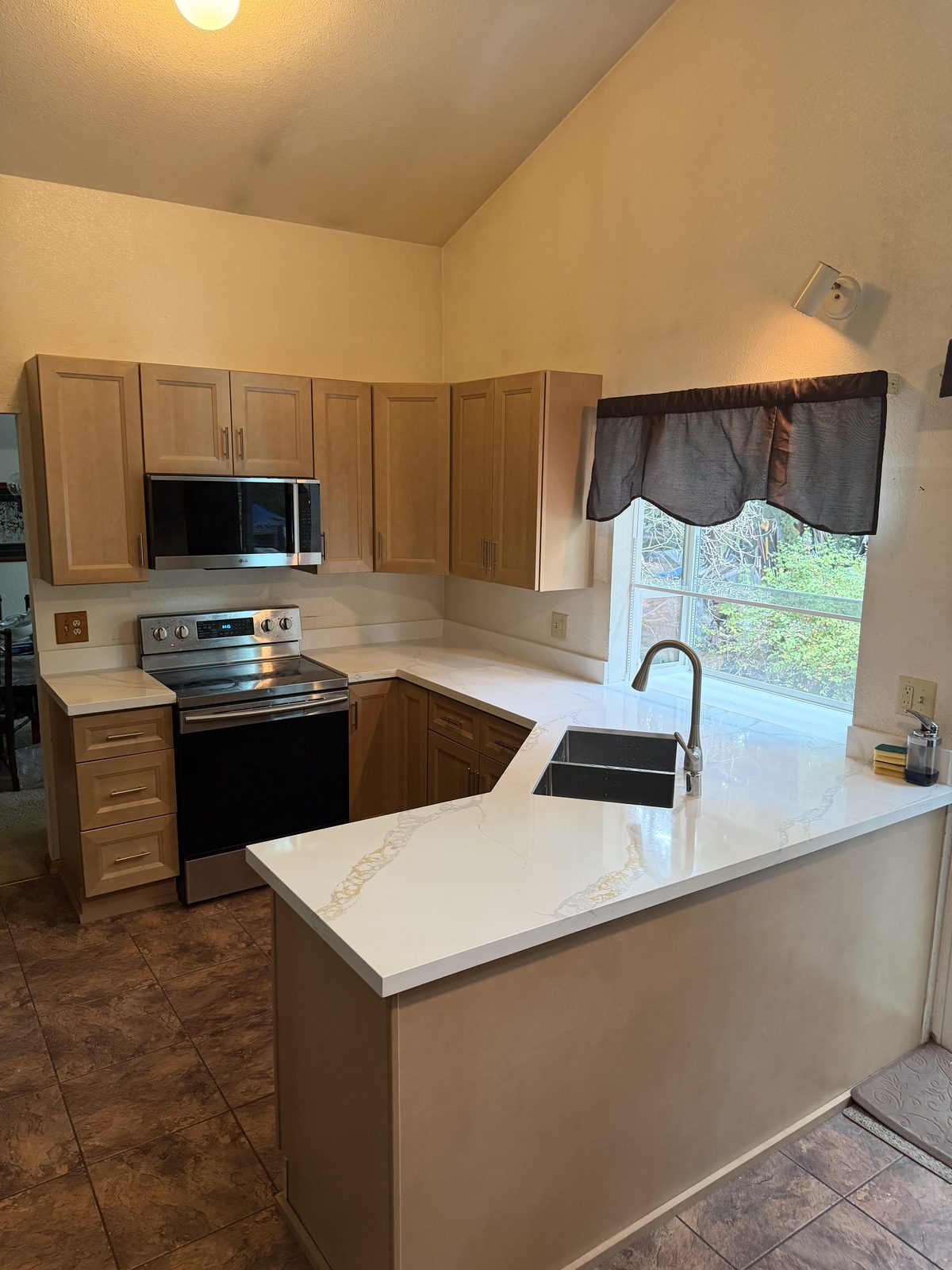 Stained cabinets and a quartz peninsula. Kitchen and bathroom in Puyallup by DA Interior Solutions
