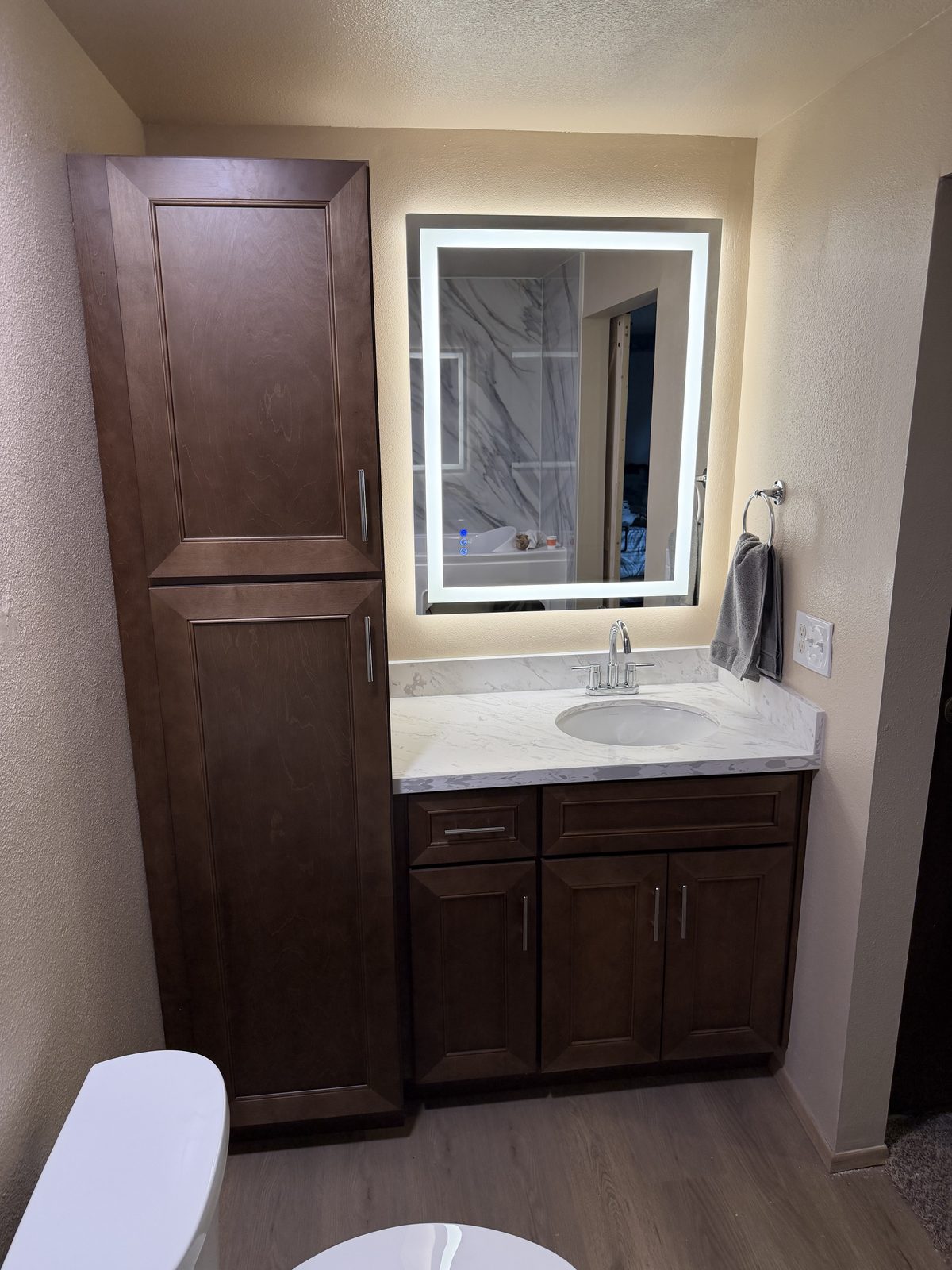 The vanity, quartz top and a light-up mirror. Kitchen and bathroom in Puyallup by DA Interior Solutions