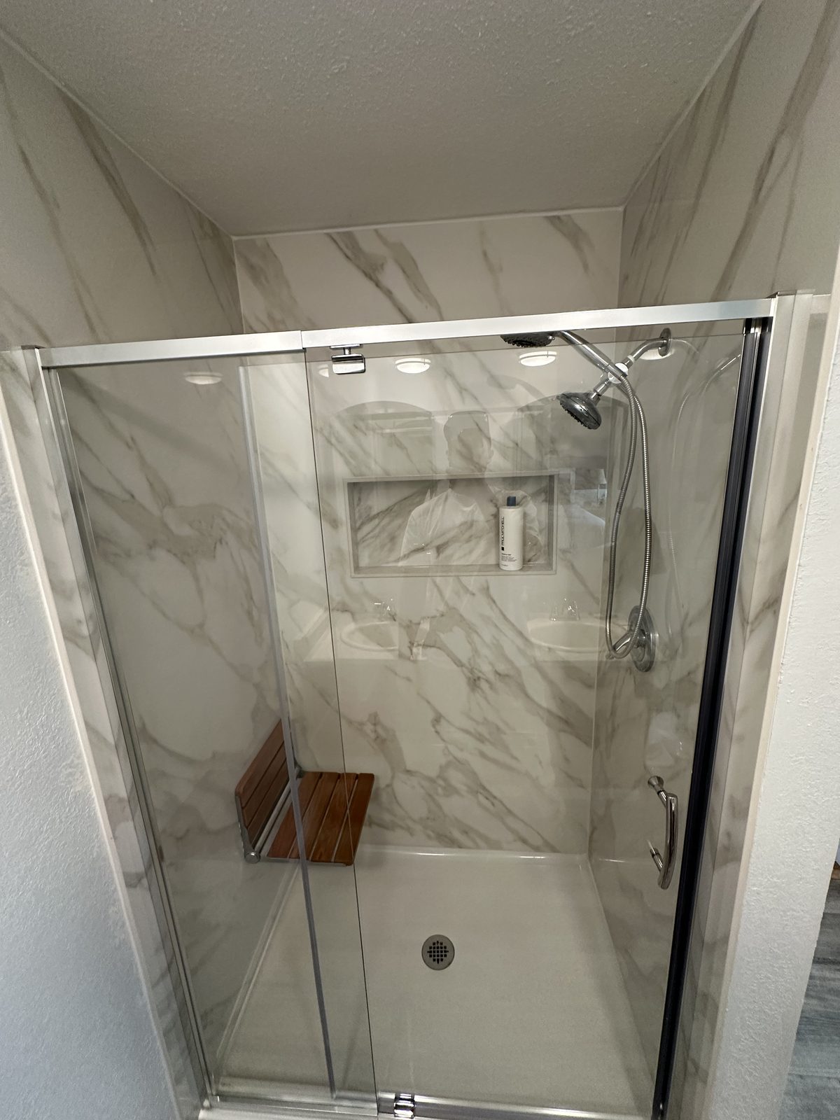 The bench and the fixtures, from the door. Shower remodel in Tacoma by DA Interior Solutions